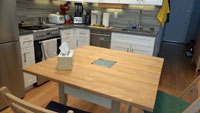 The dining table in its normal configuration.  Storage is accessible by lifting the glass tile.