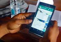 A student shows the quiz questions he has received and answered via WhatsApp on his personal smartphone.