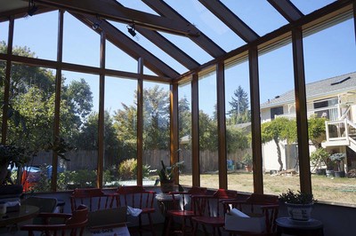 An interior view of the greenhouse showing the view from the main sunroom.  The main house is visible.
