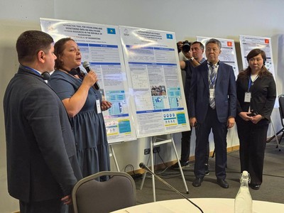 The Kazakhstan country team presents their team project poster to stakeholders and instructors.